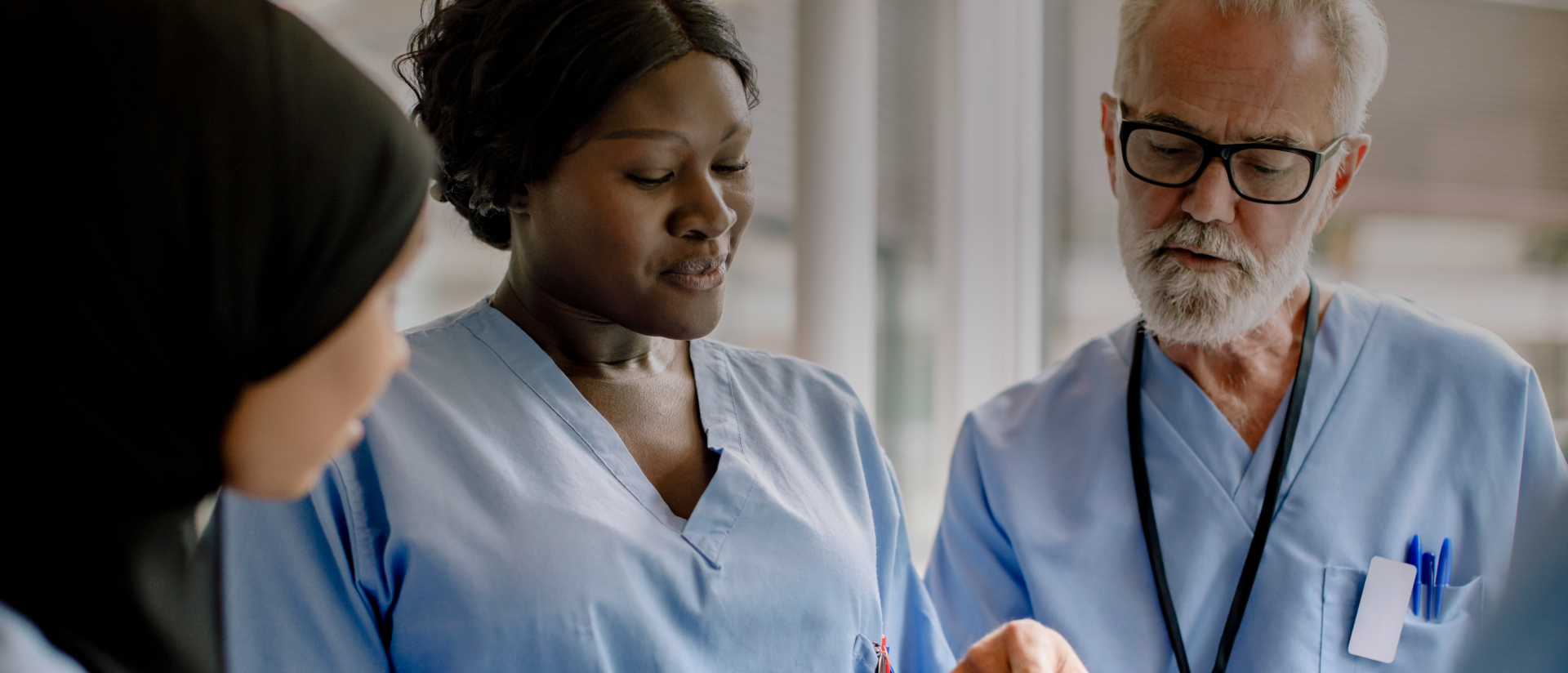 a man and two women looking at a tablet