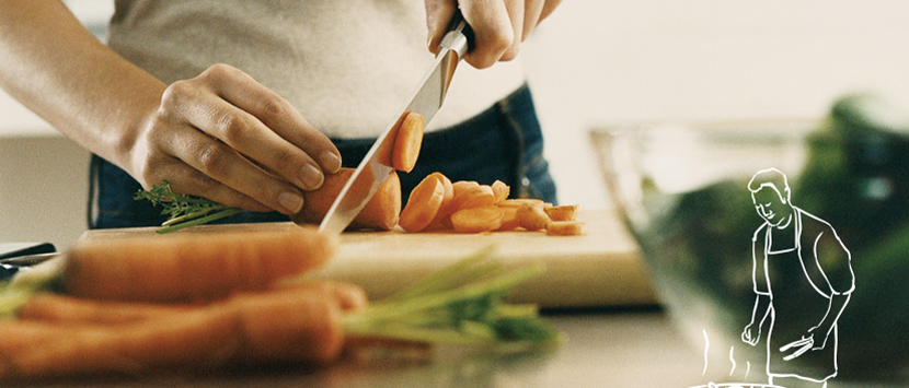 a person cutting a hot dog