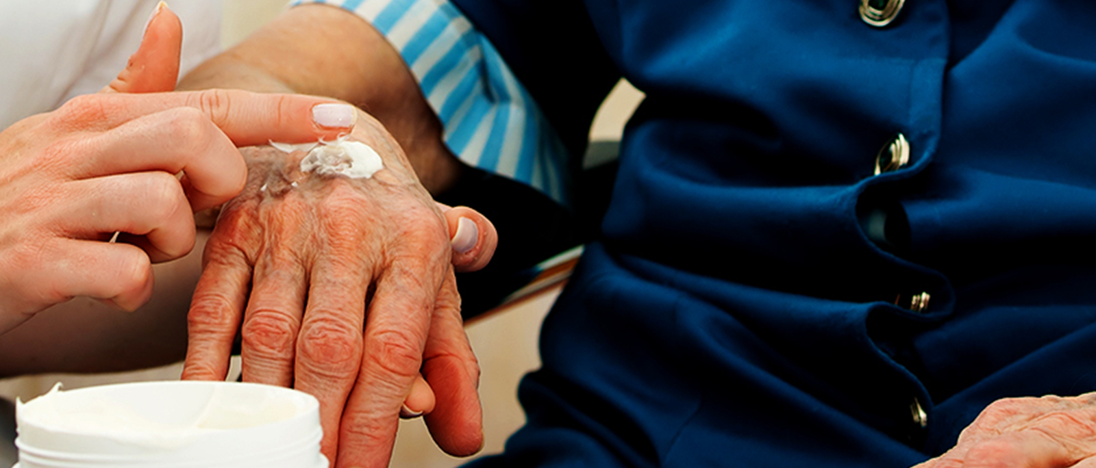 a close-up of a person applying creme to another person's hand