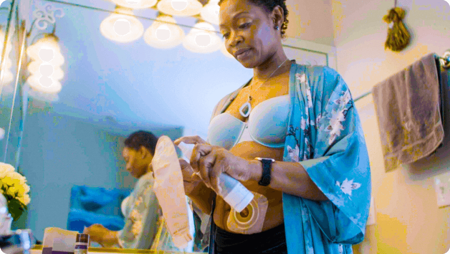 a woman applying ESENTA™ Lubricating Deodorant to an ostomy pouch