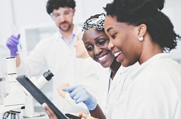 Une femme et un homme en blouse de laboratoire regardant un ordinateur