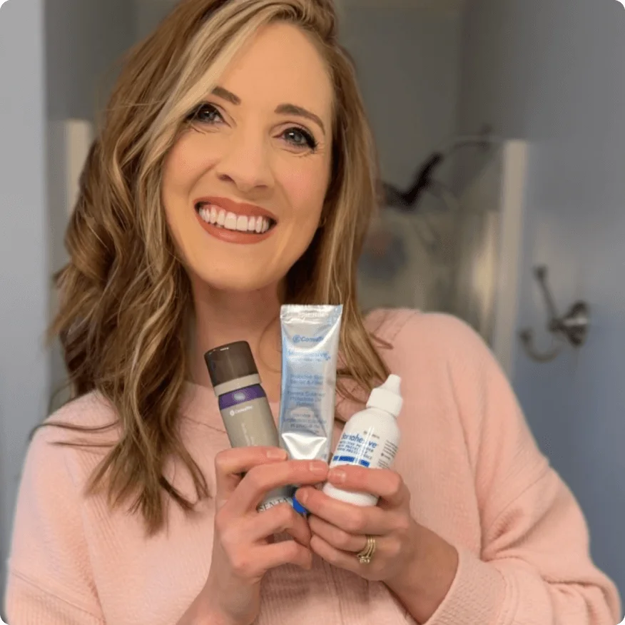 Glimlachende vrouw met Stomahesive® producten en ESENTA™ Adhesive Remover, die huidverzorging en welzijn bevorderen.