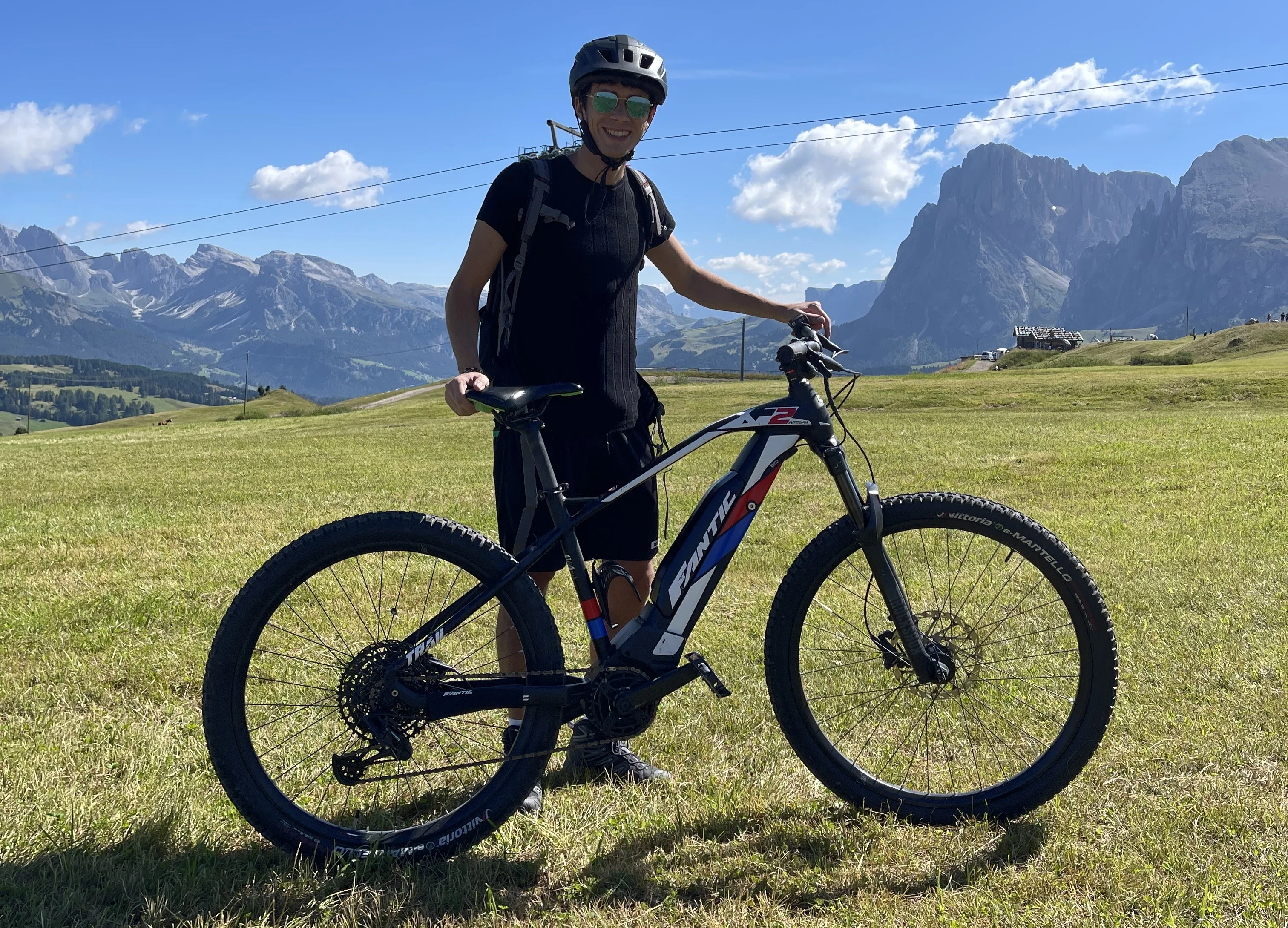山々を背景にした草原で自転車に乗った男性