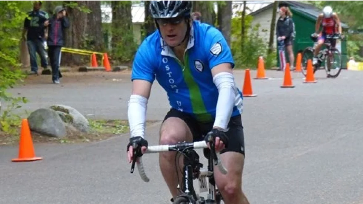 Un hombre con una ostomía disfrutando de su viaje en bicicleta durante su triatlón.
