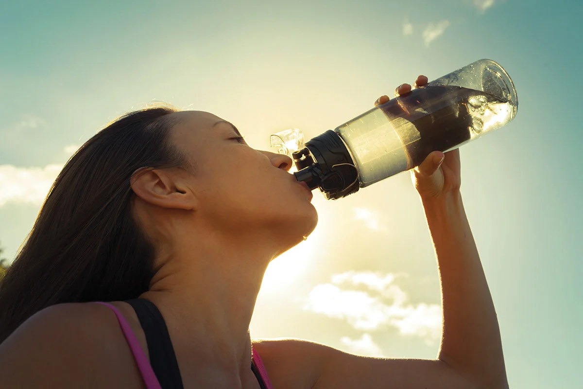 a woman drinking from a bottle